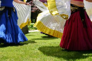Dancers wearing brightly coloured skirts in the sunshine