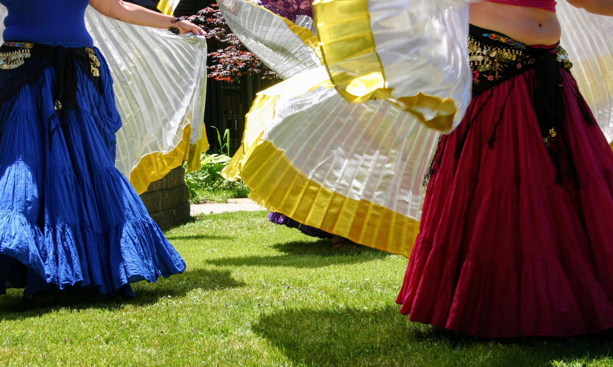 Dancers wearing brightly coloured skirts in the sunshine